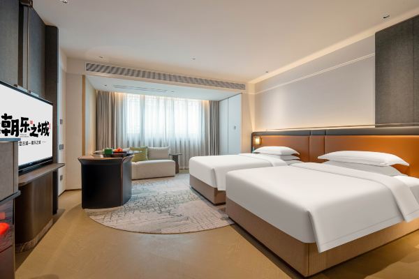 Interior of a twin room with traditional design and natural lighting.