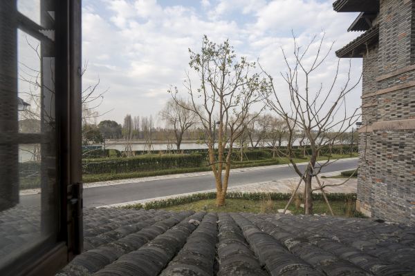 Guesthouse terrace view overlooking quiet water town canal and trees.