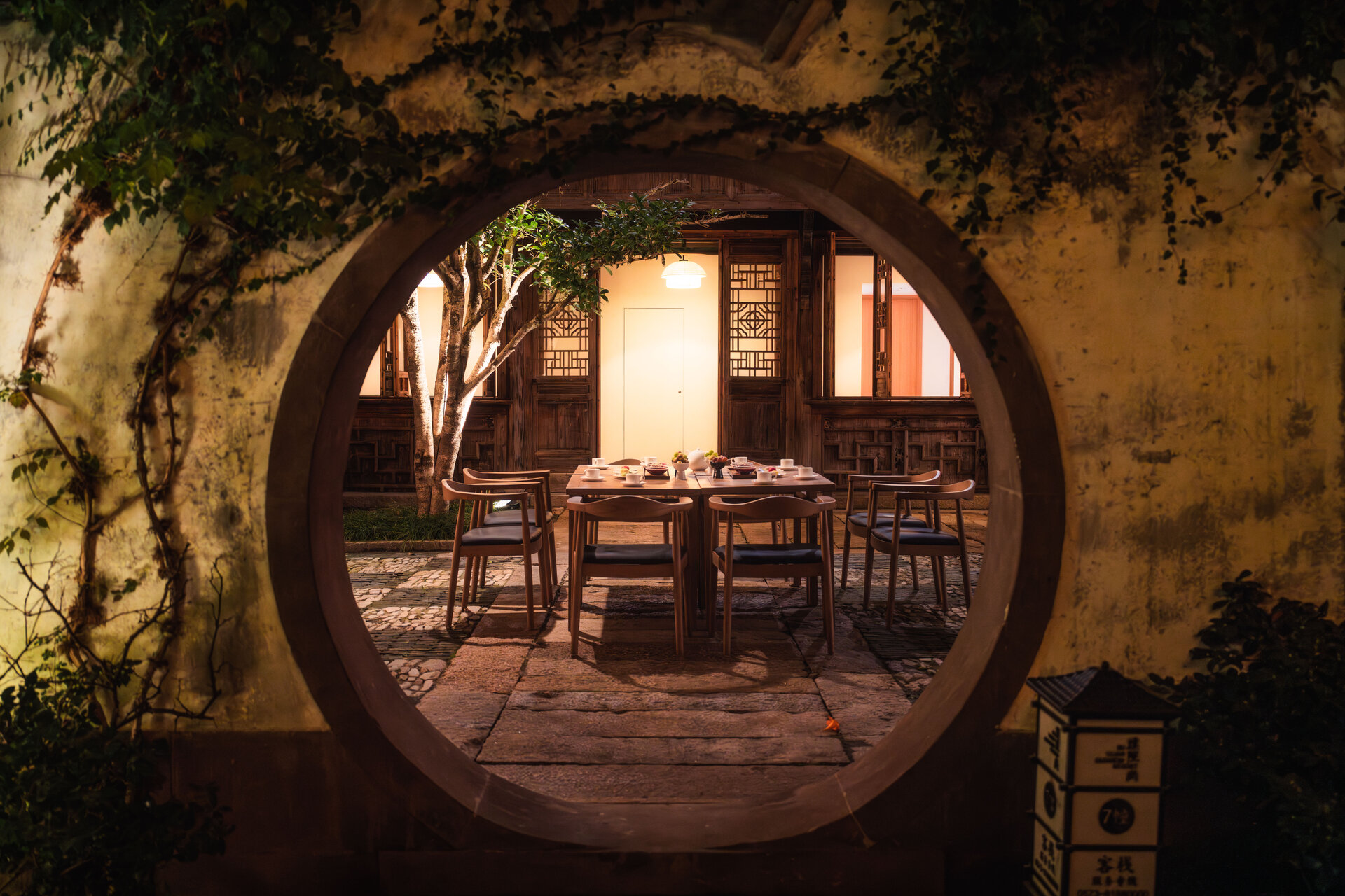 A view of the courtyard is seen through a circular door frame.