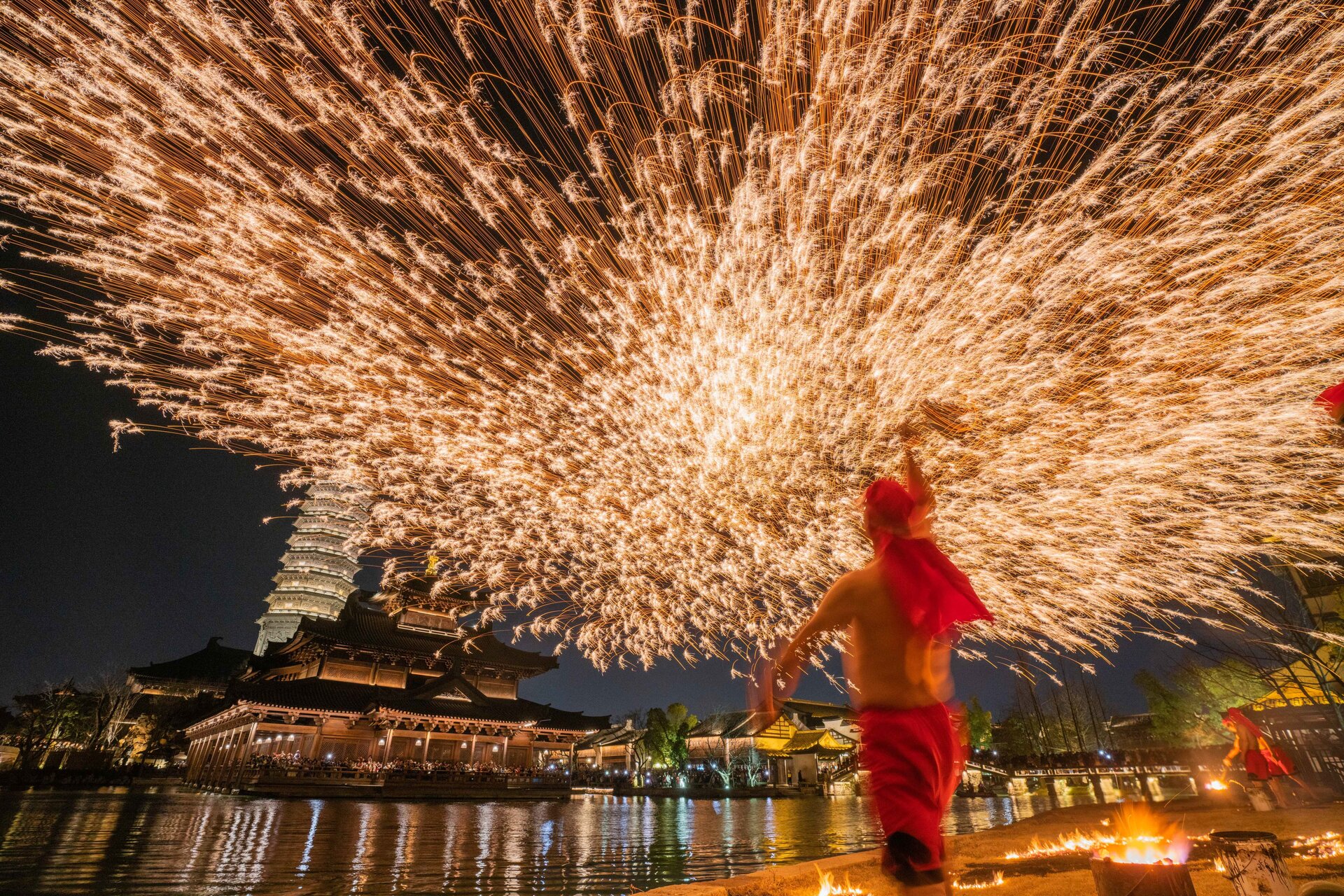 Spectacular intangible cultural heritage iron flower performance at Puyuan waterfront after dark.
