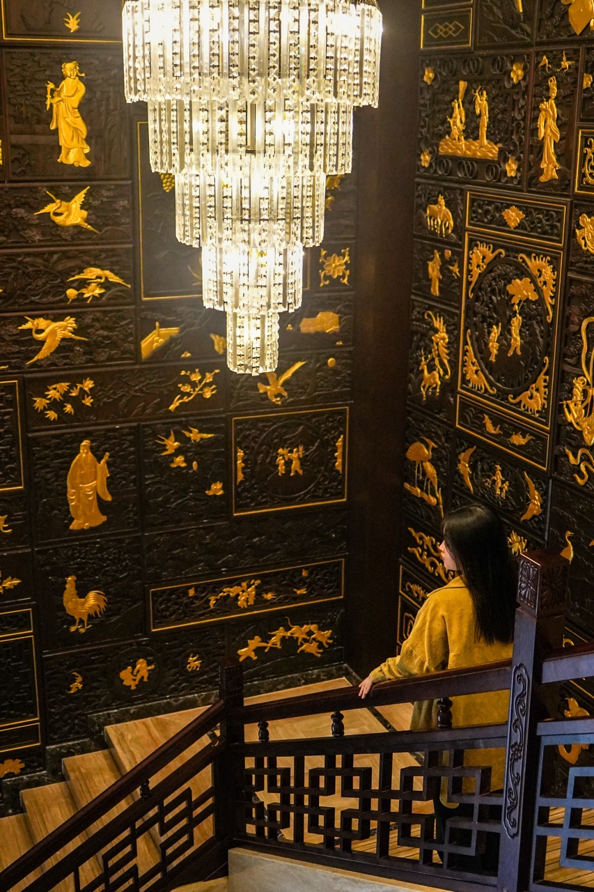 A long interior corridor with warm lighting and decorative wall panels.