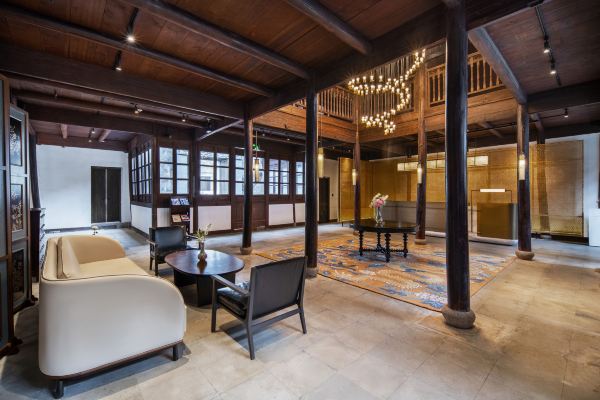 A warm and elegant hotel lobby with wooden beams, soft lighting, and a welcoming, refined interior design.