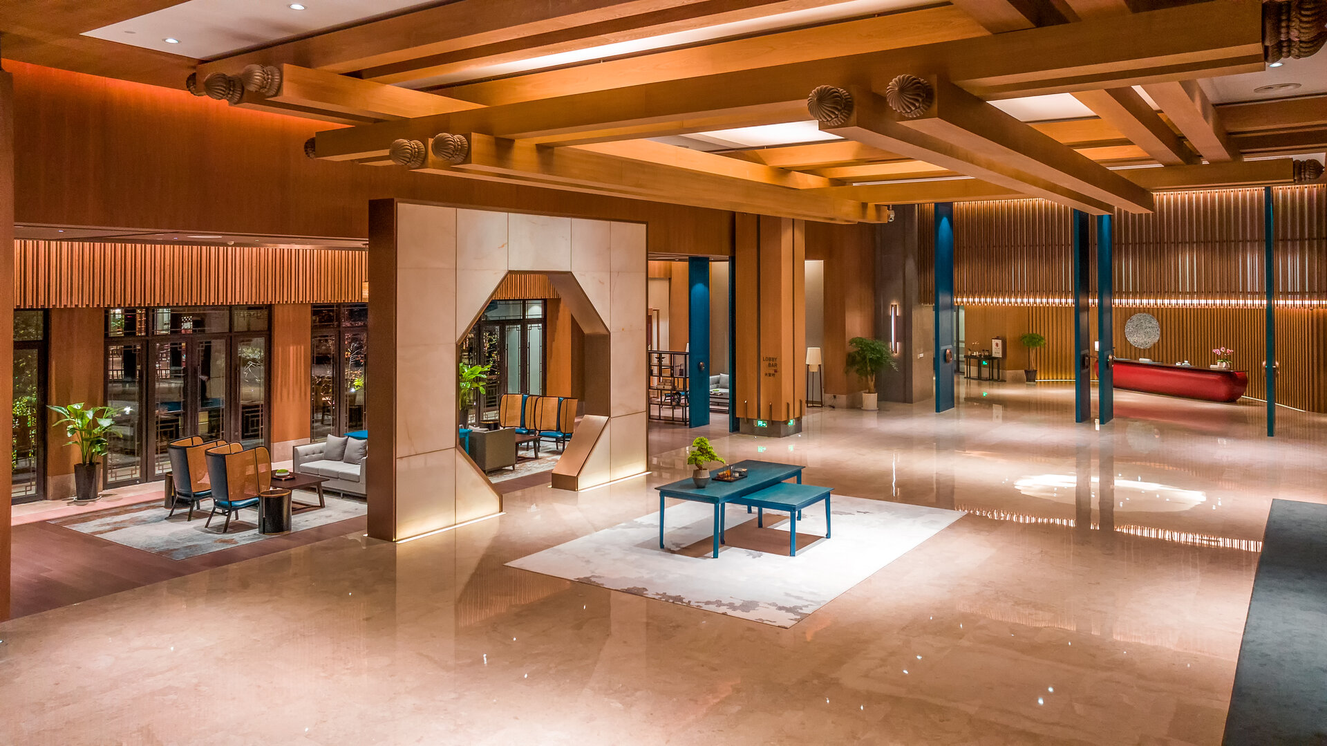 The hotel lobby features a grand reception desk and cozy lounge seating.