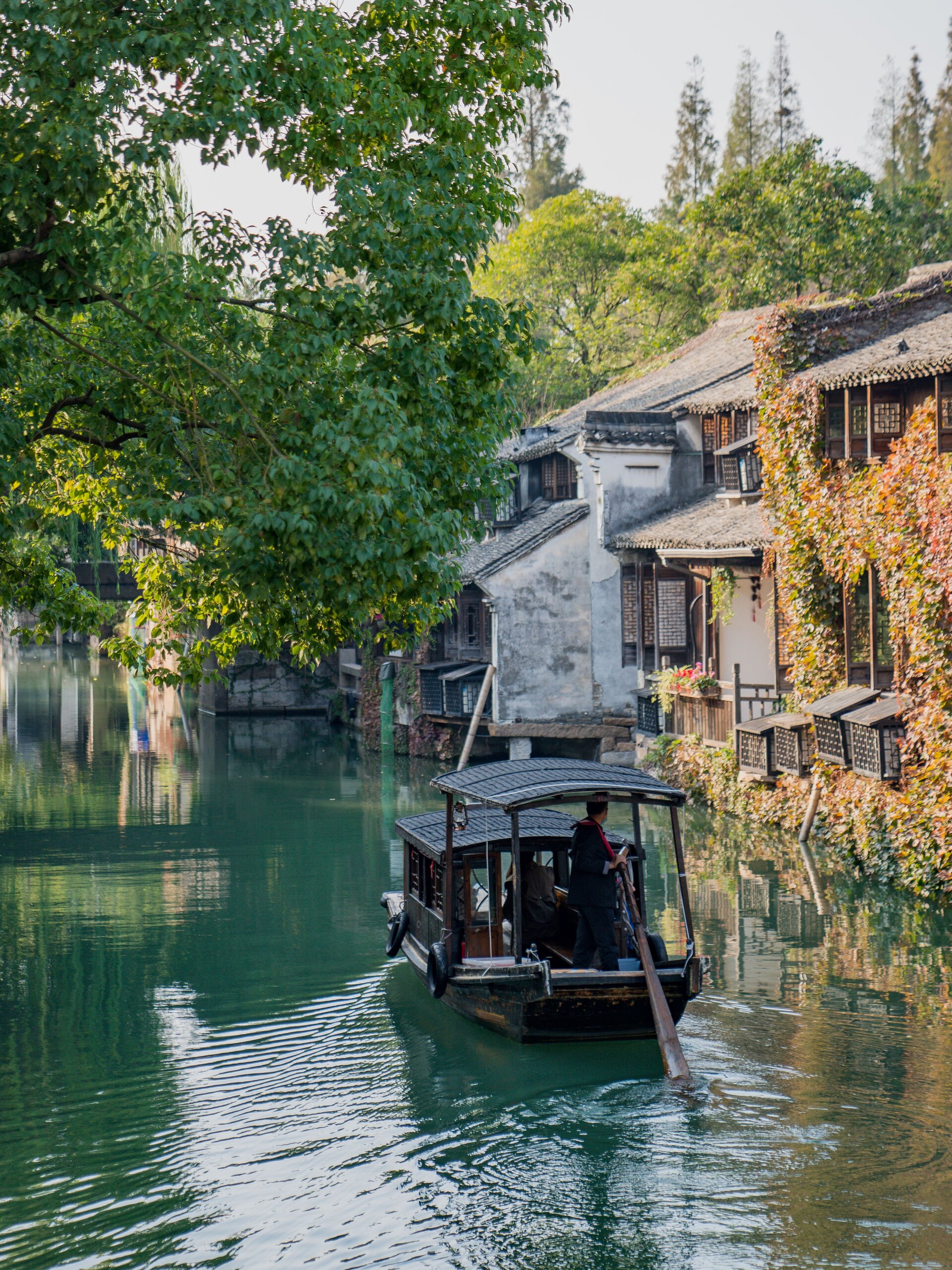Traditional wuzhen sculling boat on quiet waterway.