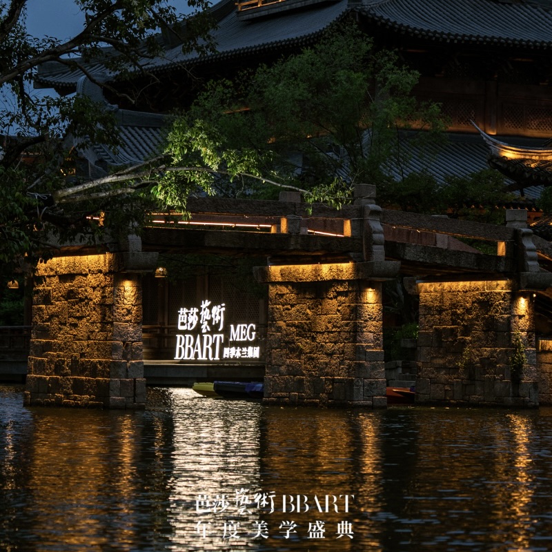 Illuminated ancient Chinese pavilion & stone bridge over canal, BBART MEG event branding glowing on waterside, dusk blue sky backdrop.