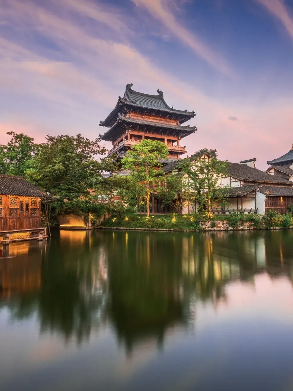 Multi-story wooden tower mirrored in quiet Puyuan waterway.
