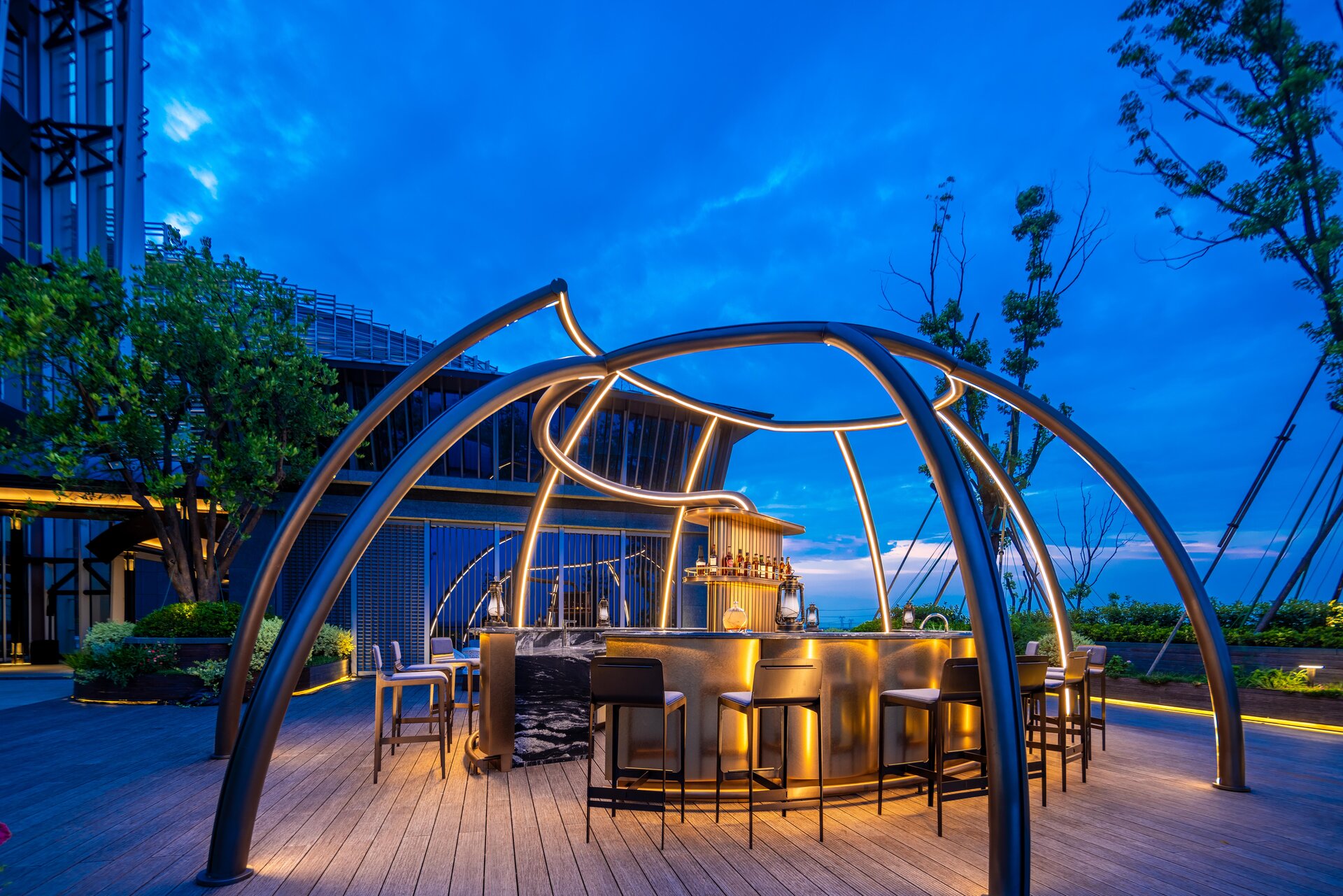 The Evening Voyage star bar at dusk with warm glowing lights and panoramic views.