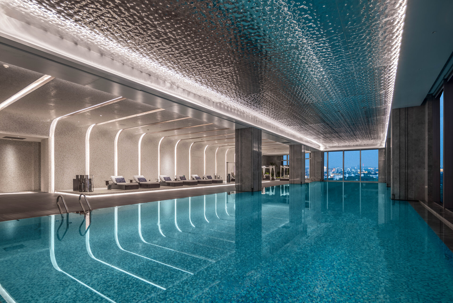 The hotel's indoor heated swimming pool with comfortable lounge chairs nearby.