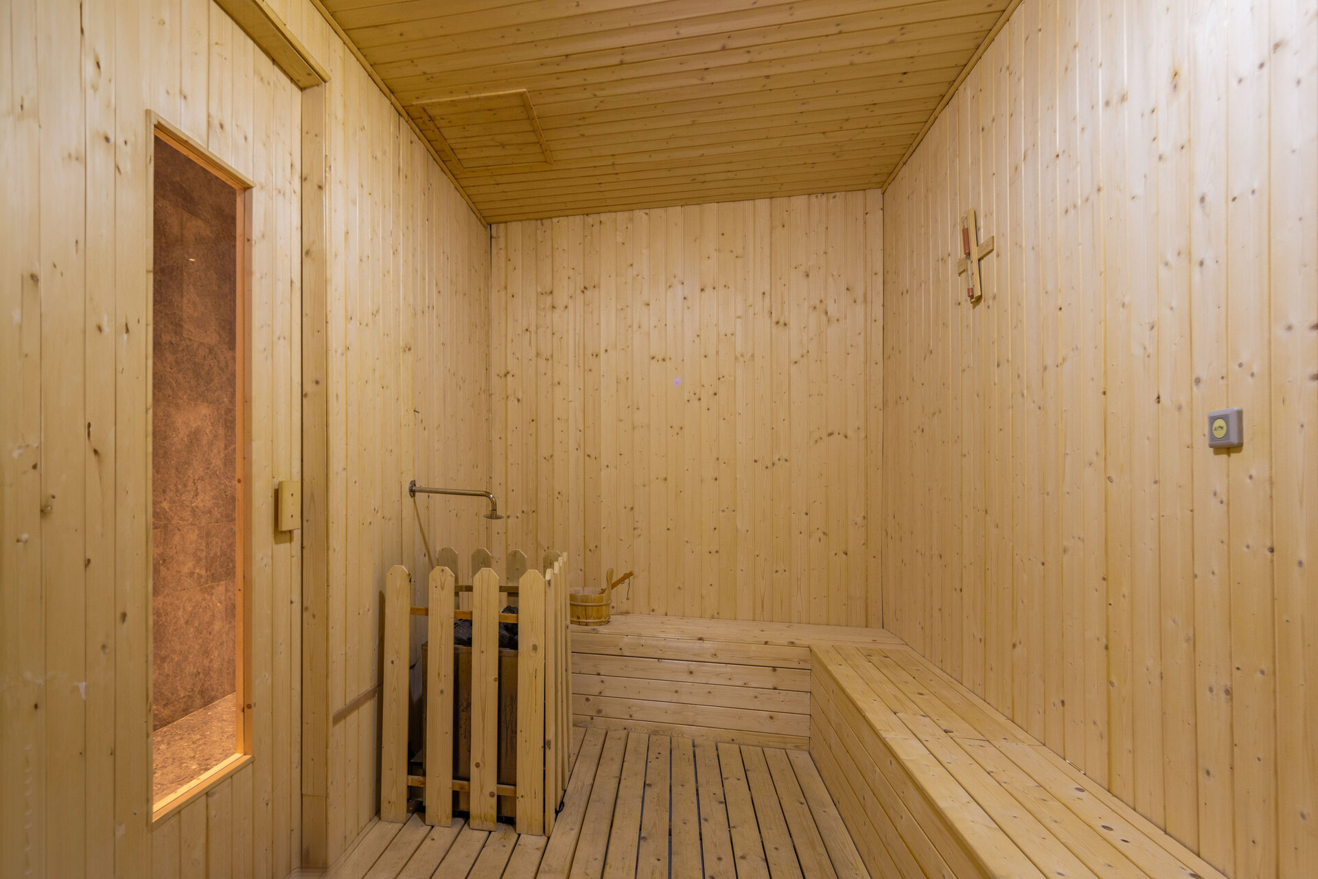 Interior view of the sauna room with wooden benches and soft lighting.