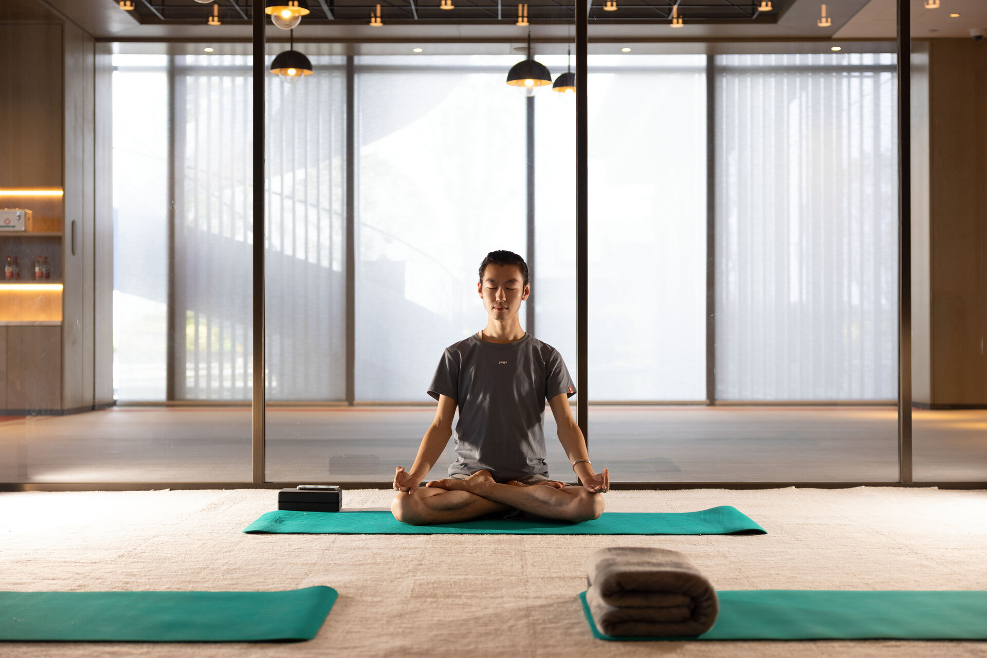 A person sits in meditation inside the tranquil yoga room.