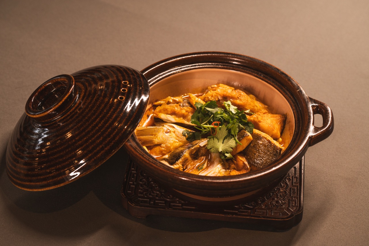 Slow-cooked fish head casserole topped with fresh coriander.