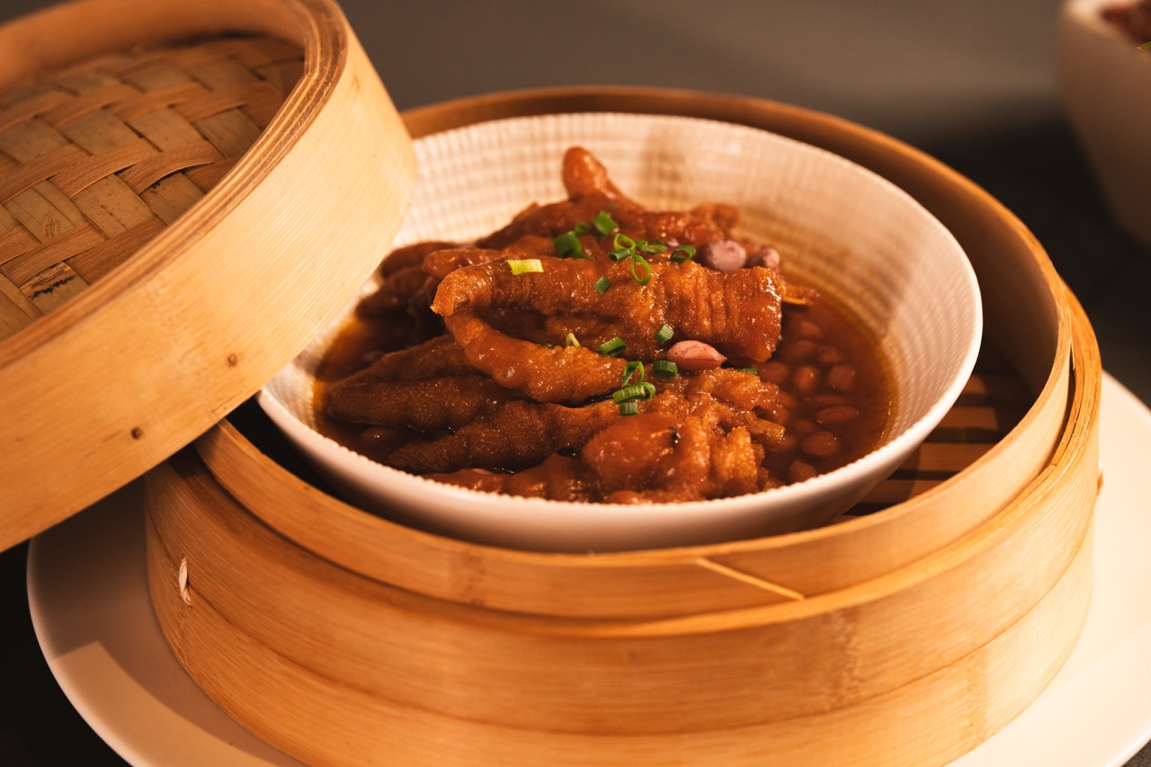 Tender braised chicken feet served in bamboo steamer.