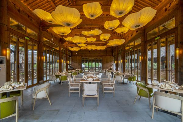 Traditional timber dining hall with lotus-shaped fabric pendant lamps and rattan dining sets.