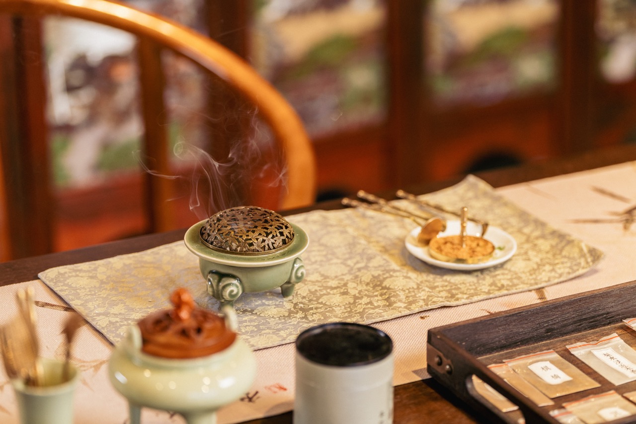 Hands crafting traditional Chinese incense in a workshop.