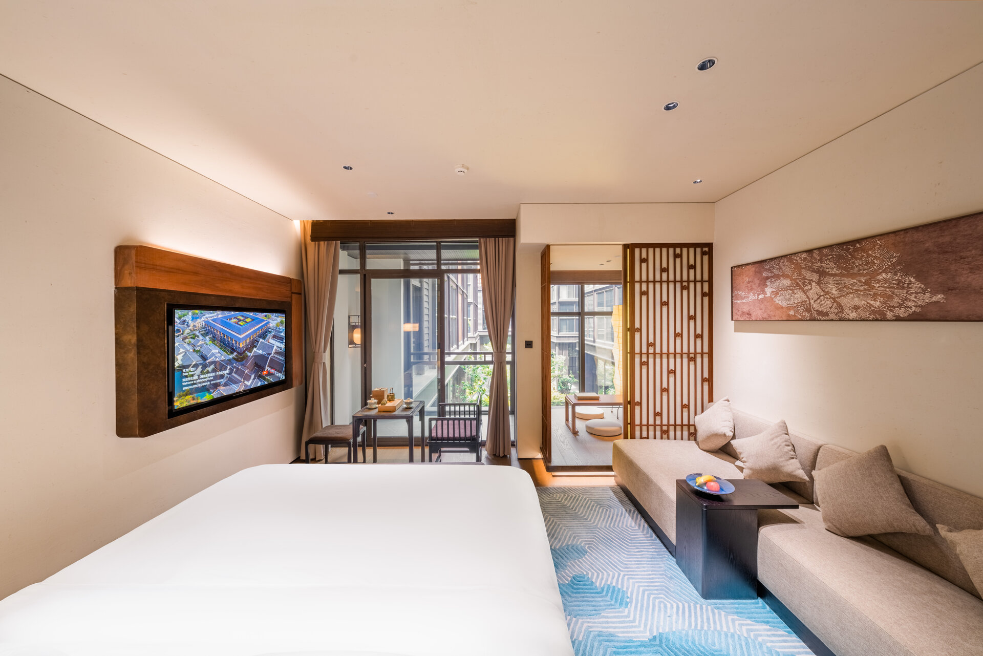 Interior of a deluxe balcony double room with modern furnishings and balcony access.