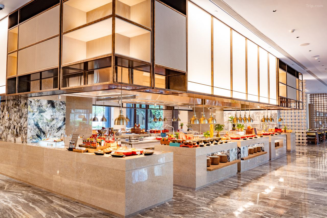Luxury marble buffet station with brass pendant lamps, abundant fresh food display and glass partition cabinetry.