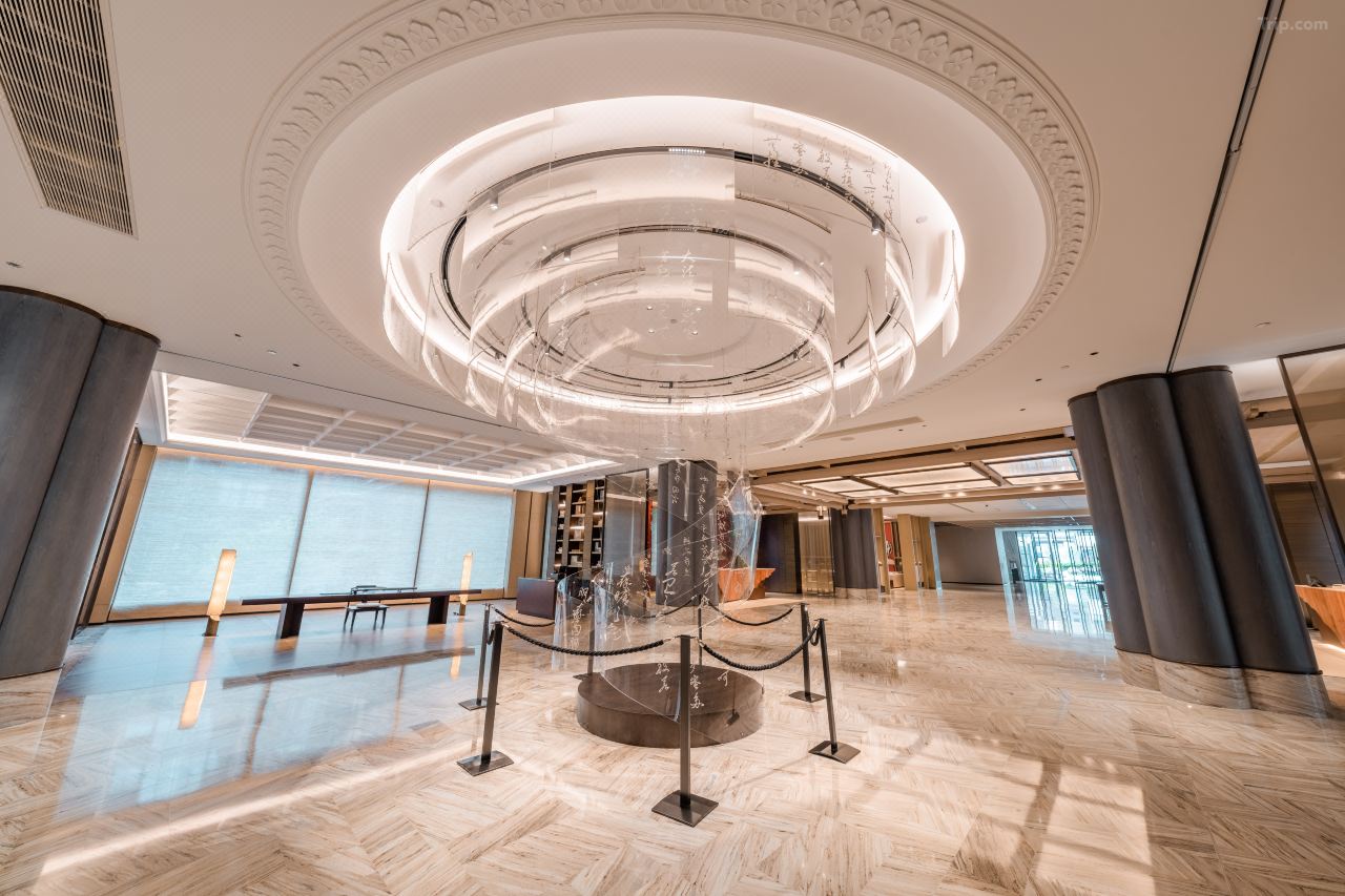 Spacious marble lobby with multi-layer acrylic circular art sculpture under carved circular ceiling molding.