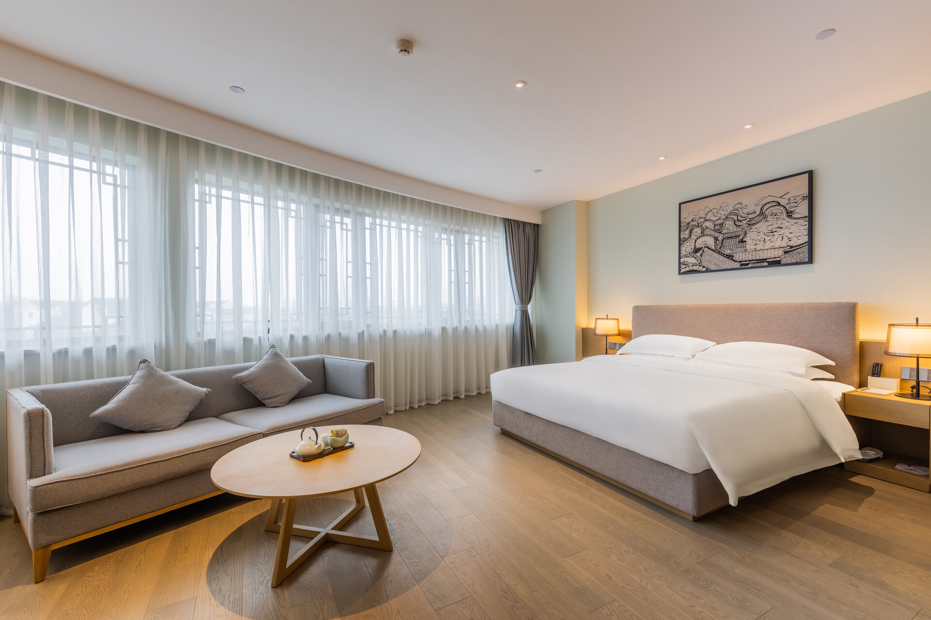 Interior of a deluxe double room with modern furnishings and large bed.