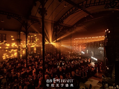 Wide shot of packed grand event hall with stage spotlight for BBART Annual Aesthetics Gala.
