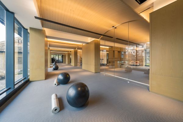 Fitness room with cardio machines and open workout space.