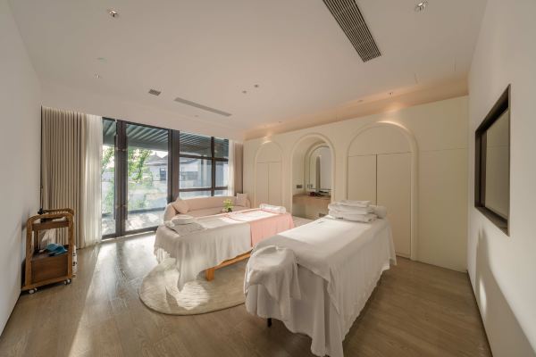 Bright spa treatment room with minimalist decor and large windows.
