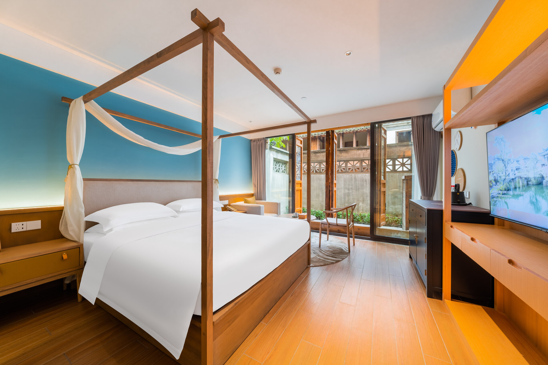 Interior of a deluxe courtyard double room with large bed and courtyard access.
