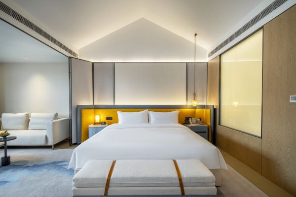 A spacious double room with two beds, soft lighting, and a clean, modern design for a comfortable stay.