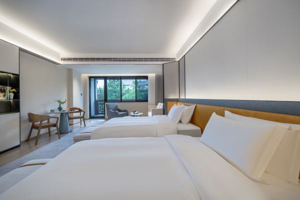 Interior of a deluxe river view balcony twin room with balcony and river-facing view.