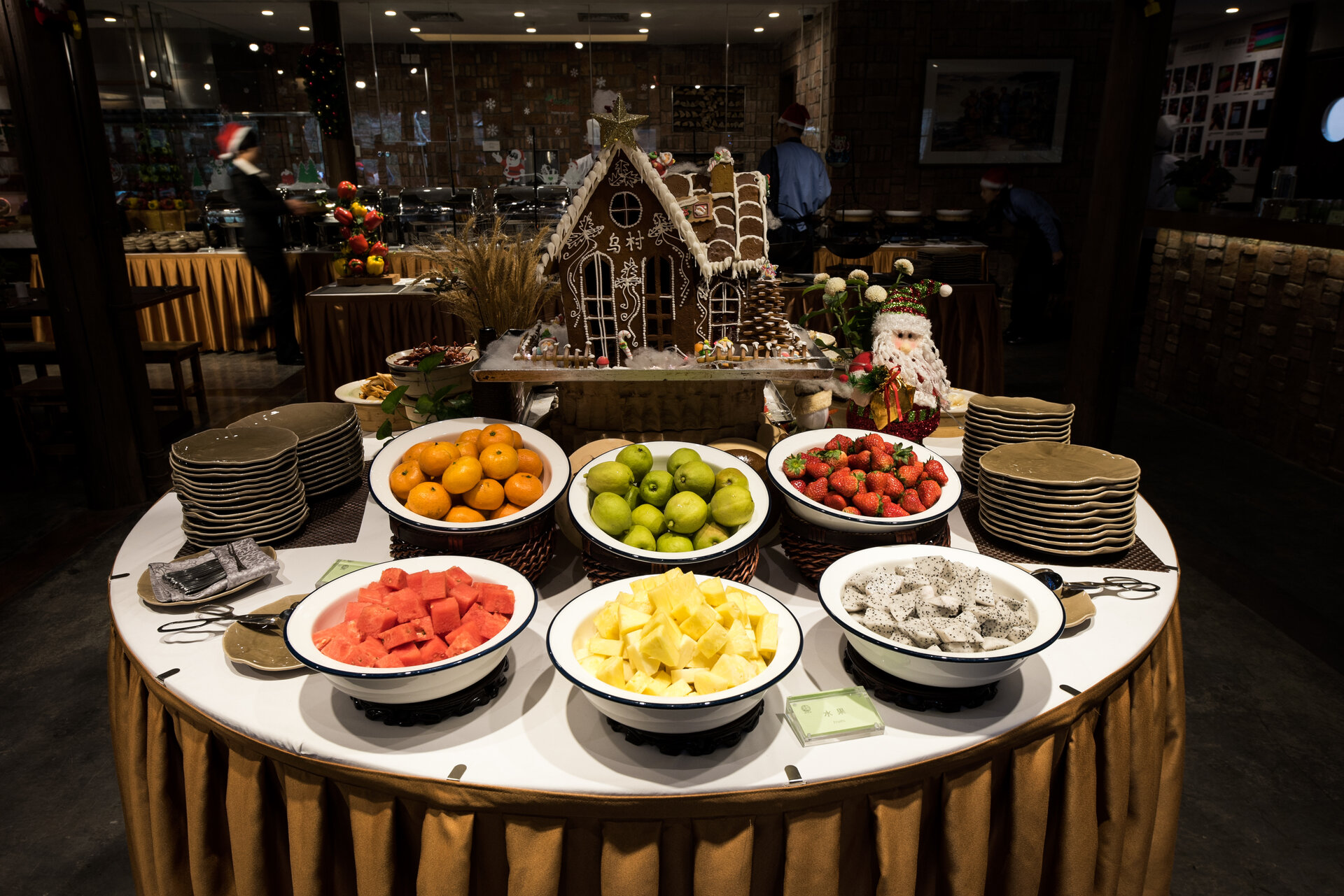 Fruit platter buffet at Zhiqin Era Restaurant decorated with Christmas gingerbread cottage marked Wucun.